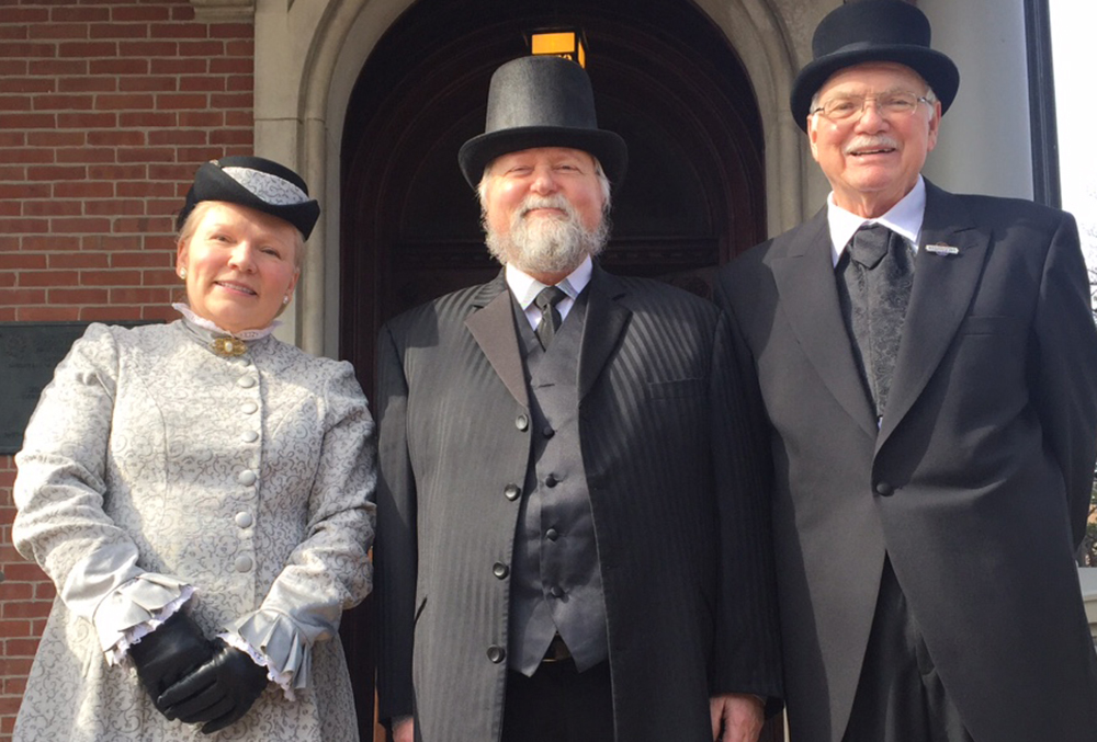Photograph of Harrison family reenactors, posed in front of the front door of the presidential mansion.