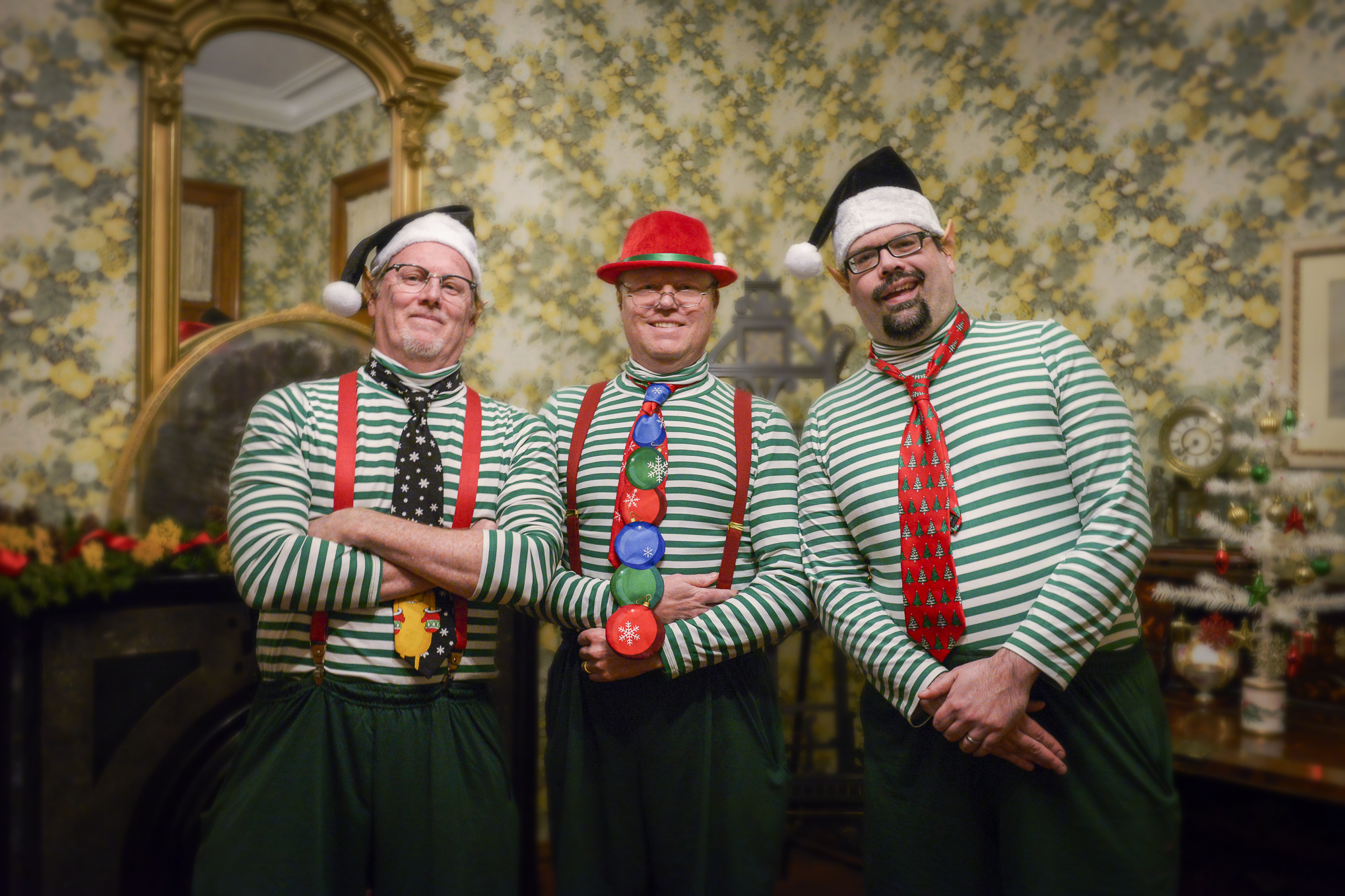 Photo of three men dressed like festive elves inside the Benjamin Harrison Home.