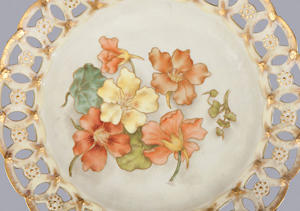 Designed and hand-painted by Mrs. Caroline Scott Harrison with hand painted orange and yellow Nasturtiums. Edge is a cutout lace pattern with gold paint.