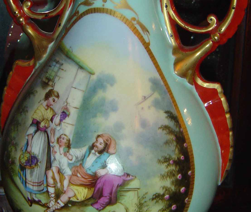 Porcelain blue vases, gold trim and orange-red handles. Hand painted street scenes with child on man's lap and woman holding grapes. Wedding gifts from Mrs. Harrison's father, John W. Scott, to Mrs. William Bridges about 1874-75.