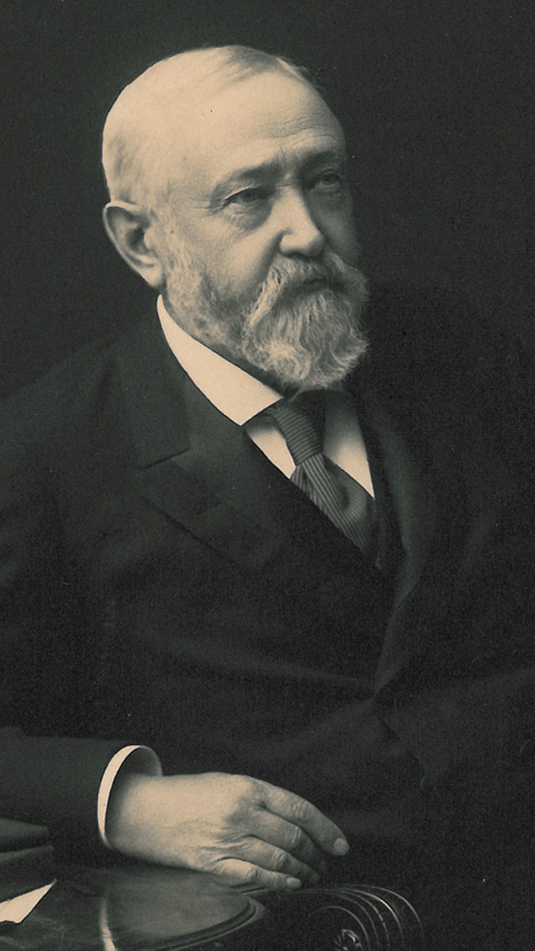 Benjamin Harrison seated in a chair with a table