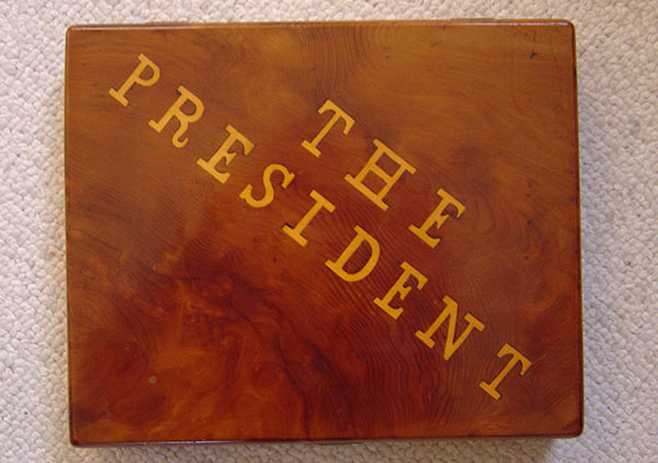 Wooden cigar box with inlaid top that says 