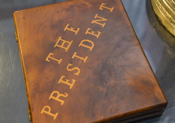 Wooden cigar box with inlaid top that says 