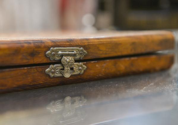 Wooden cigar box with inlaid top that says 