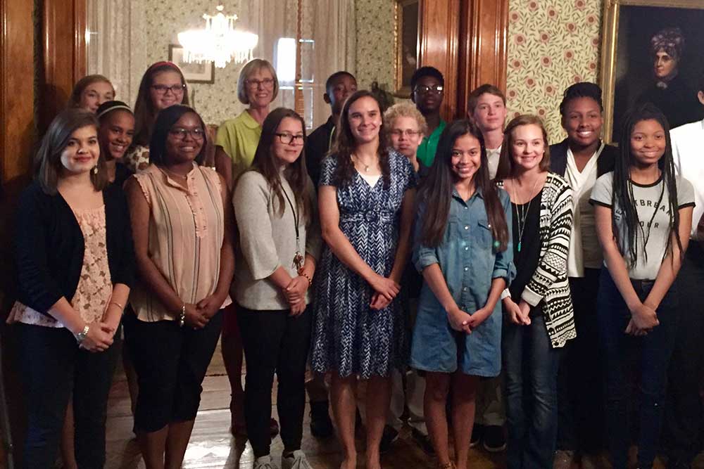 Lieutenant Governor Suzanne Crouch poses with students in the back parlor of the Harrison Home.