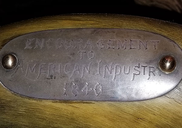 Several plaque on the back and arms of the chair convey the following: Top plaque: 