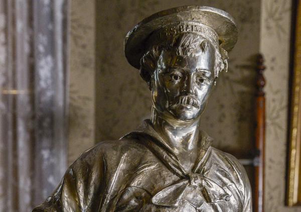 Full figure of a man in sailors uniform with hat. Figure has right hand on hip and left hand at side. Base has inscription 