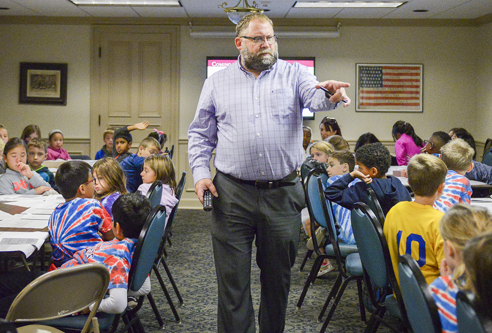 Photo of Roger Hardig teaching a group of school kids.
