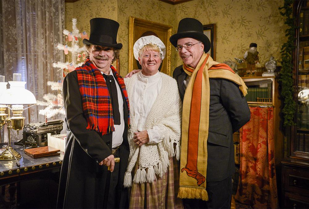 Photograph of a trio of Candlelight Theatre actors, captured in the office of the Benjamin Harrison home. They're dressed for the Twas the night before performance.